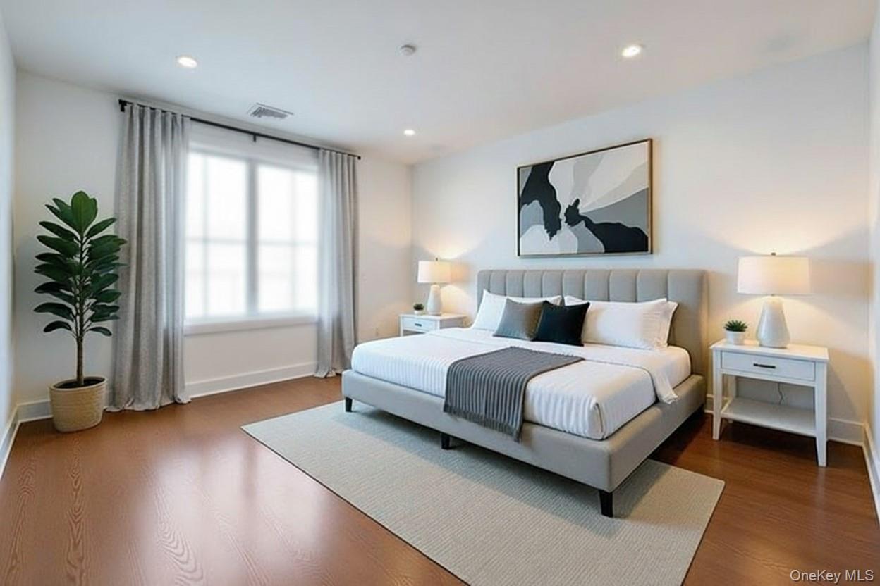 291 Main Street, Unit 1C Eastchester, NY 10709 - Photo 6 of 14 a bedroom with a large bed and a potted plant