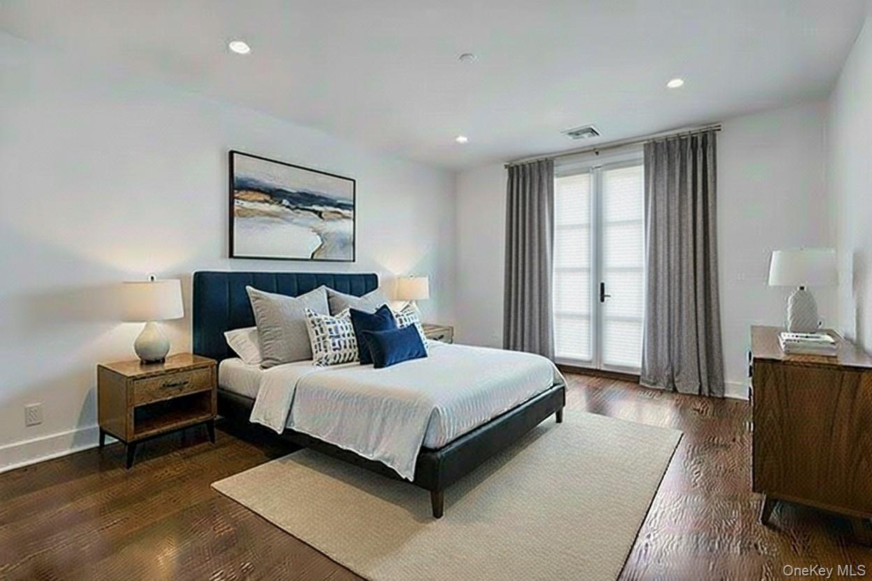 291 Main Street, Unit 1C Eastchester, NY 10709 - Photo 10 of 14 a bedroom with a bed and wooden floor