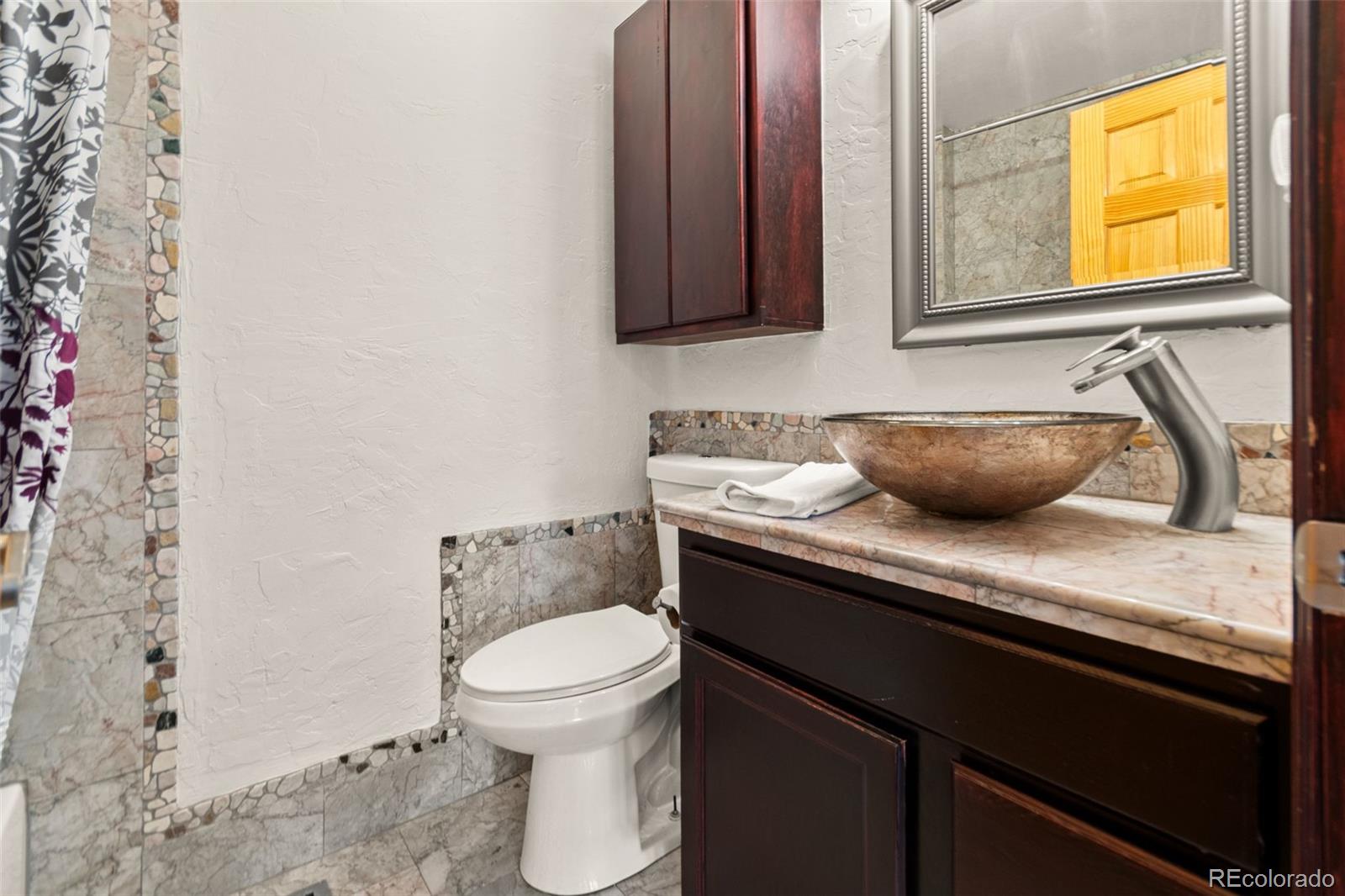 202 Badger Lane Bailey, CO 80421 - Photo 30 of 50 a bathroom with a granite countertop sink and a toilet