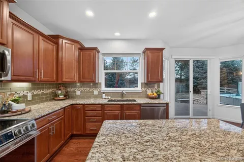 a kitchen with stainless steel appliances granite countertop a stove a sink and a microwave