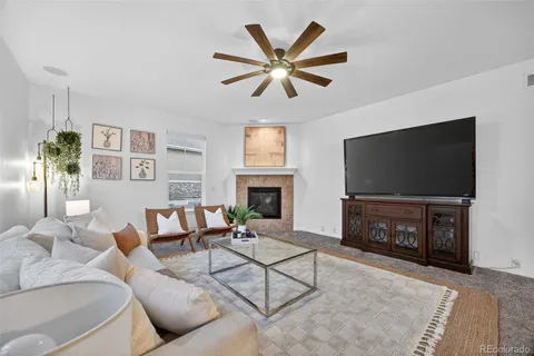 a living room with furniture a flat screen tv and a fireplace