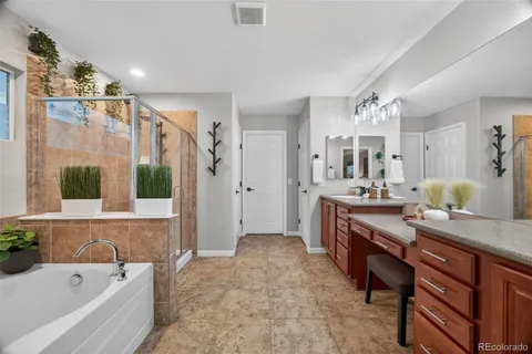 a spacious bathroom with a granite countertop tub sink and mirror