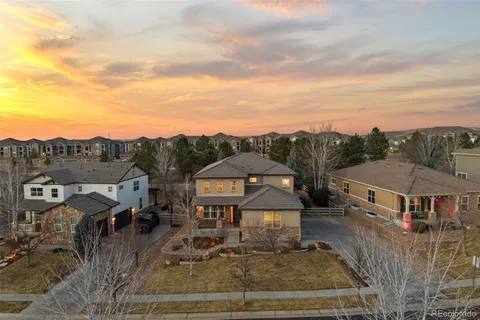 a view of a big house with a big yard plants and large trees