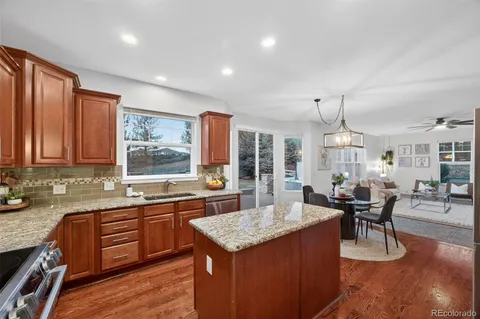 a kitchen with granite countertop sink stove and dining table