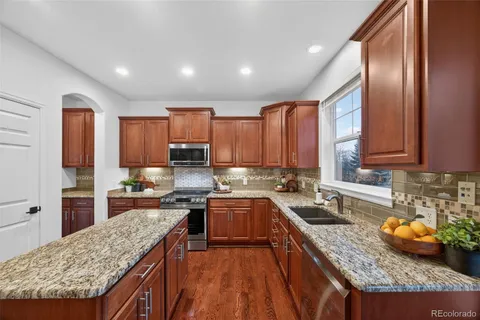 a kitchen with large cabinets appliances a sink and a counter top space