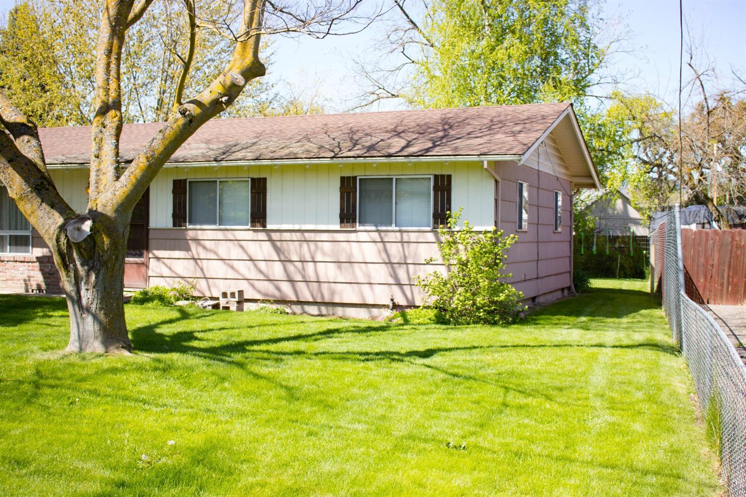 2613 Table Rock Road Medford, OR 97501 - Photo 23 of 23 a view of a white house with a large tree and a yard table and chairs