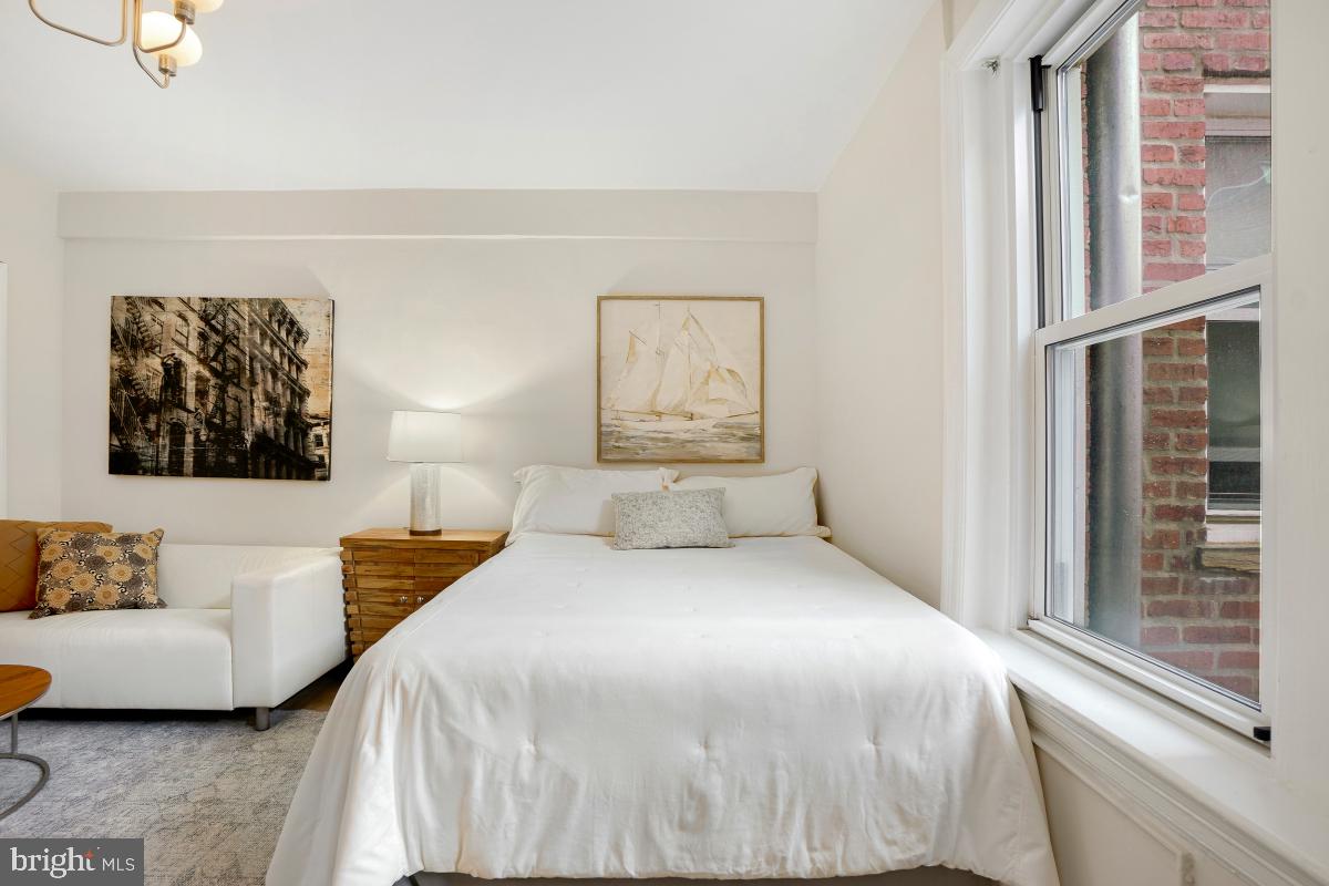 1954 Columbia Road Northwest, Unit 308 Washington, DC 20009 - Photo 18 of 51 a bedroom with a bed and a couch with window