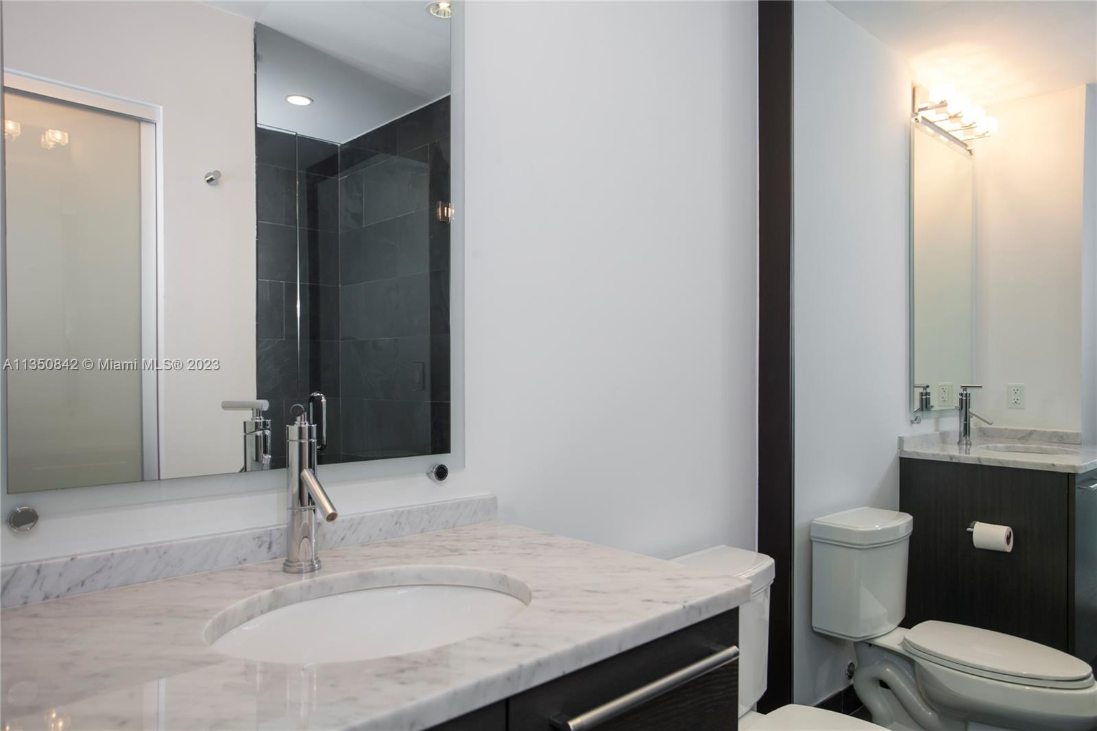 900 Biscayne Boulevard, Unit 4804 Miami, FL 33132 - Photo 10 of 17 a bathroom with a granite countertop sink and a mirror