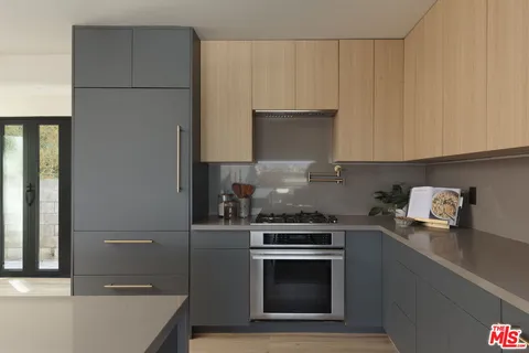 a kitchen with granite countertop a sink stove and refrigerator