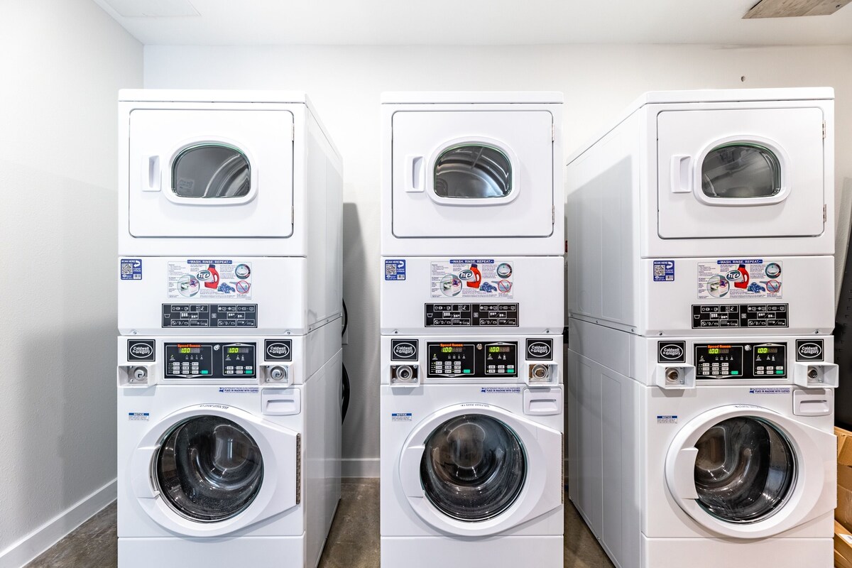 49 Navasota Street, Unit 201 Austin, TX 78702 - Photo 13 of 13 Communal laundry room featuring stacked washing machine and dryer
