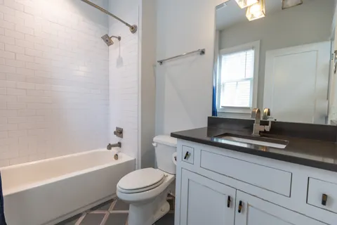 a bathroom with a granite countertop sink toilet and shower