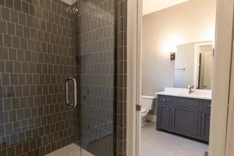a bathroom with a granite countertop sink a toilet and shower