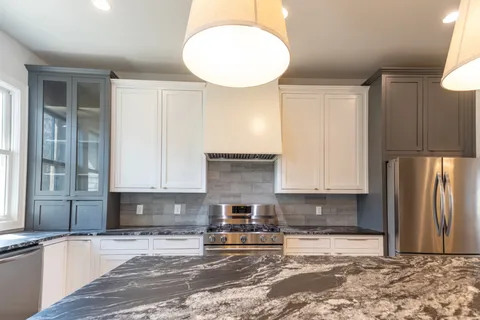 a kitchen with stainless steel appliances granite countertop a refrigerator and a stove top oven