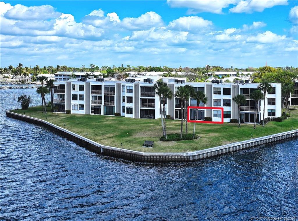 a view of a building with a big yard and large trees