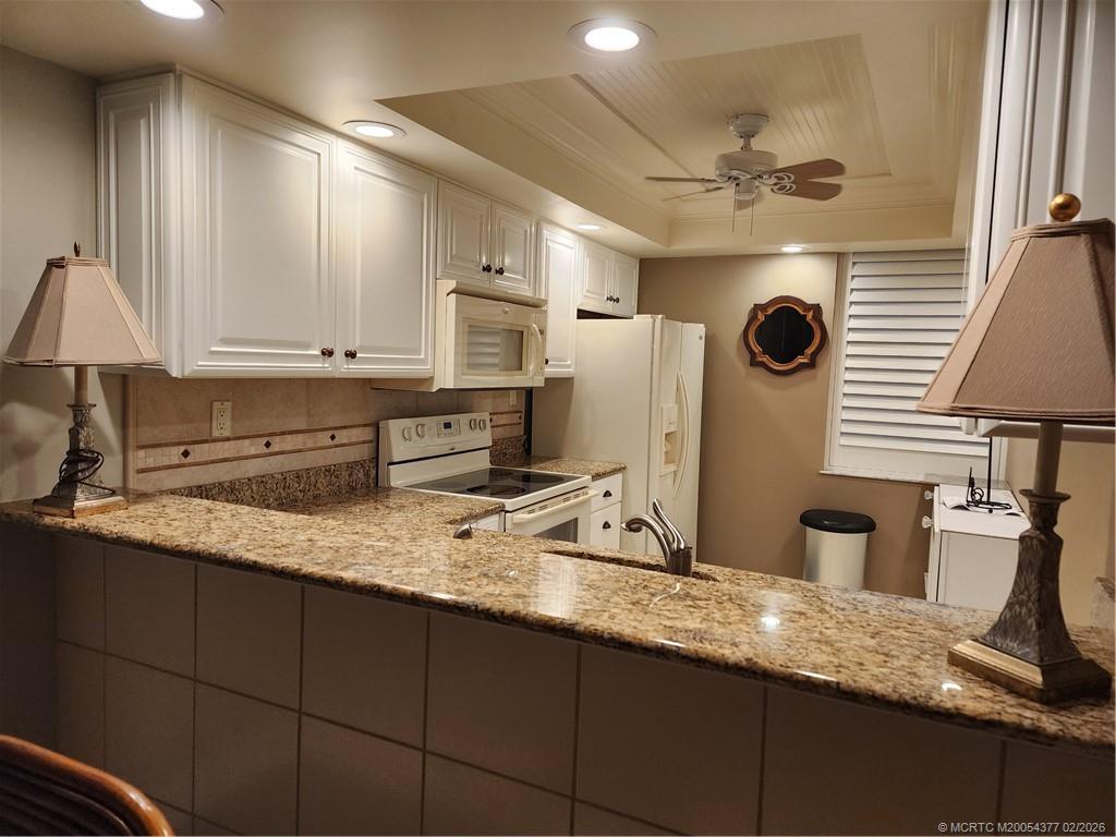 1950 Southwest Palm City Road, Unit 13102 Stuart, FL 34994 - Photo 11 of 40 a kitchen with stainless steel appliances granite countertop a sink a stove and a microwave