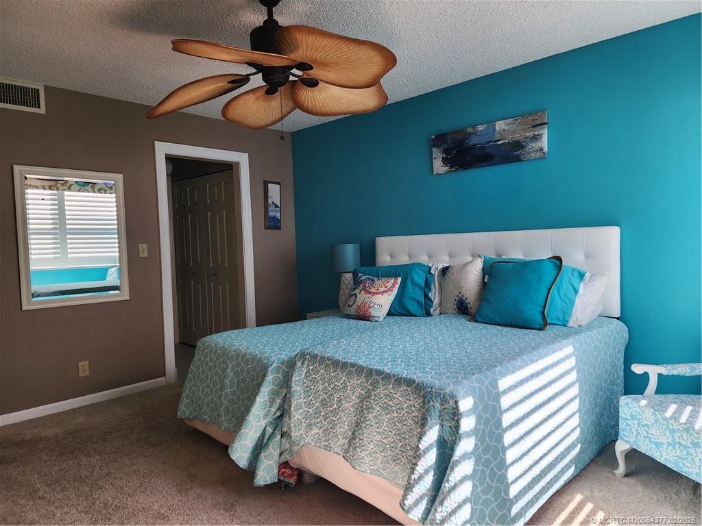 1950 Southwest Palm City Road, Unit 13102 Stuart, FL 34994 - Photo 22 of 40 a bedroom with a bed and a chandelier