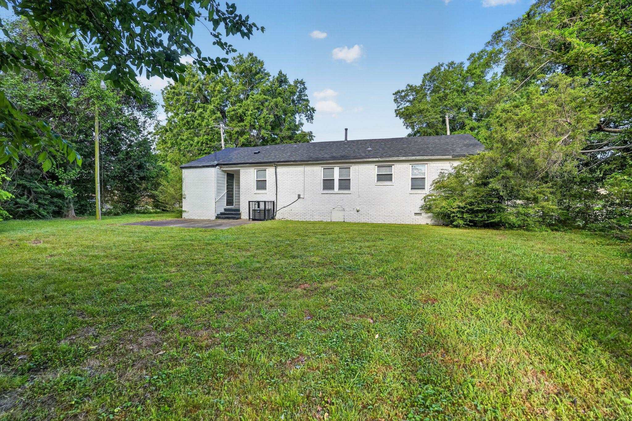 4686 Gill Road Memphis, TN 38109 - Photo 5 of 32 Expansive backyard featuring a large grass area and mature perimeter trees