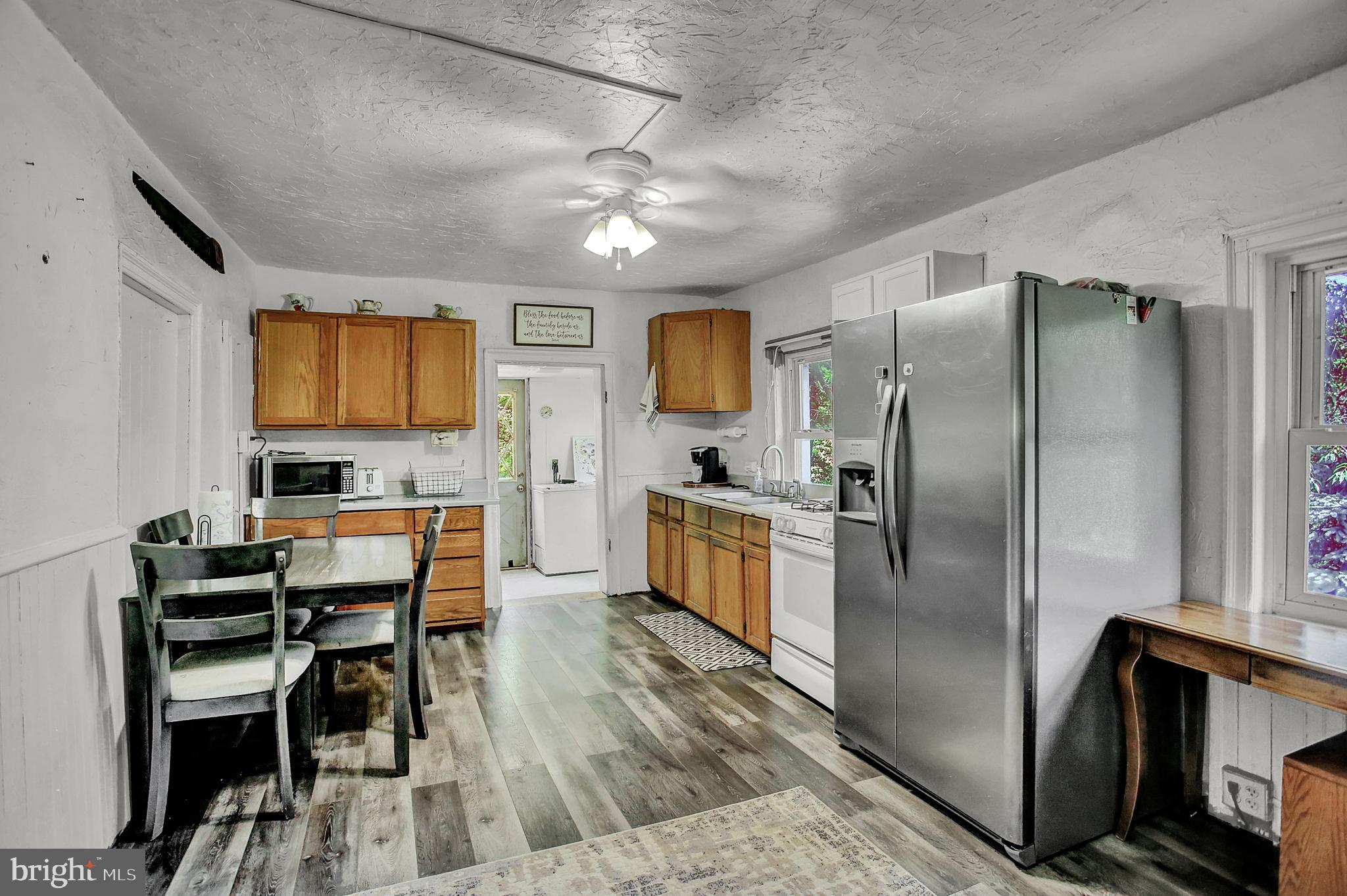 61 Baltimore Street Spring Grove, PA 17362 - Photo 18 of 51 a kitchen with stainless steel appliances granite countertop a refrigerator a stove a microwave a dining table and chairs with wooden floor