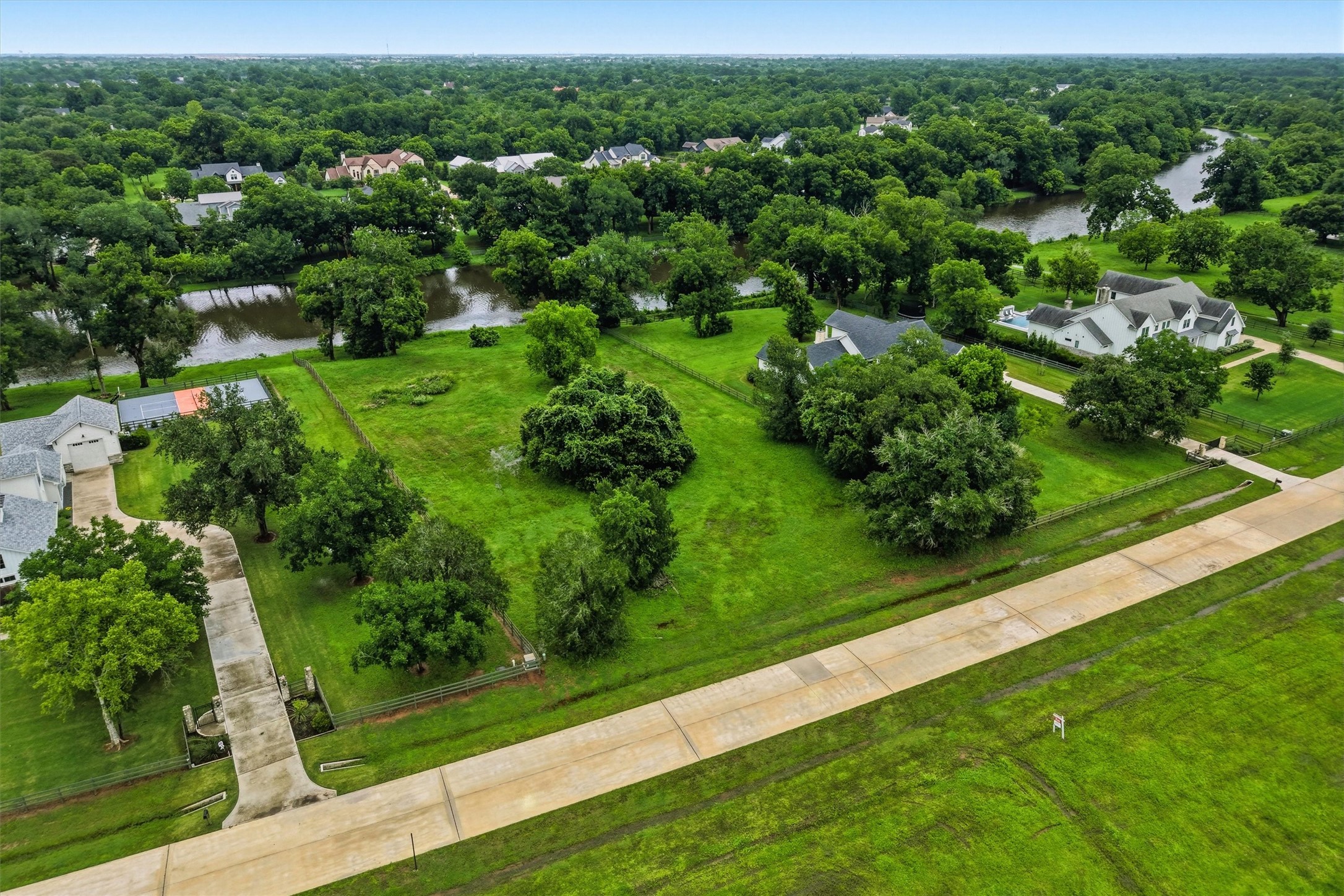 0 Riverlake Road Fulshear, TX 77441 - Photo 38 of 47 Another aerial perspective highlights the expansive dimensions of this premier homesite and its idyllic setting among luxury custom residences. The spacious acreage allows ample room for a sprawling estate, pool, guest house, workshop, or additional outdoor amenities.