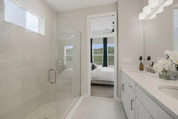 a en suite spacious bathroom with a double vanity sink a mirror and a shower