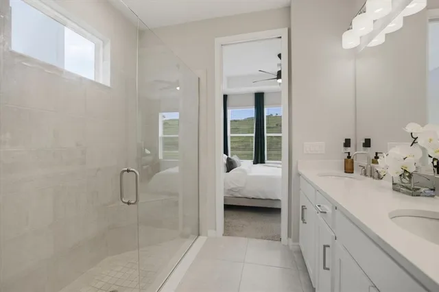 a en suite spacious bathroom with a double vanity sink a mirror and a shower