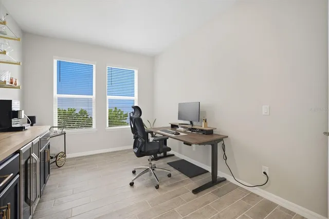 a view of a workspace with furniture and a window