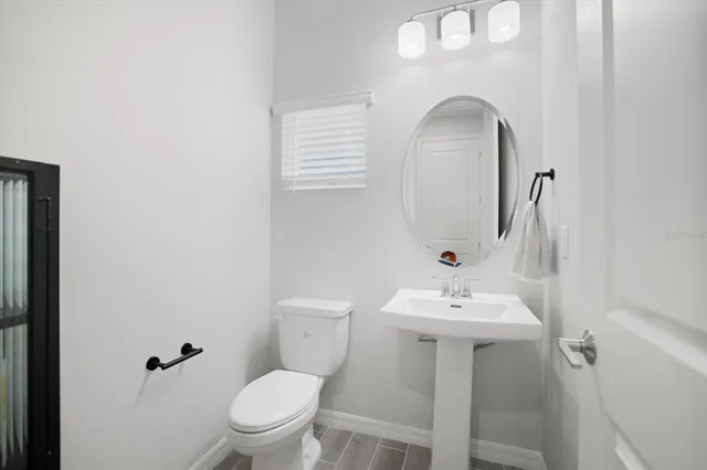 a bathroom with a sink mirror and toilet