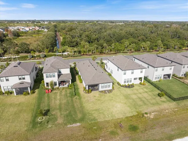 an aerial view of residential houses with outdoor space and trees