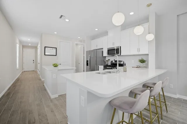 a kitchen with kitchen island a stove a table and chairs in it