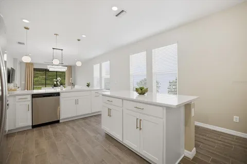 a kitchen with white cabinets and sink