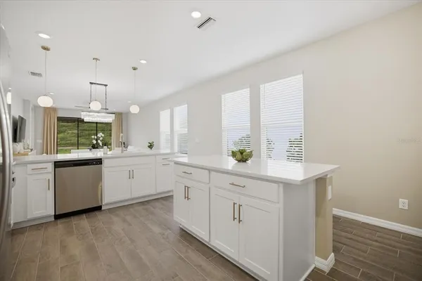 a kitchen with white cabinets and sink
