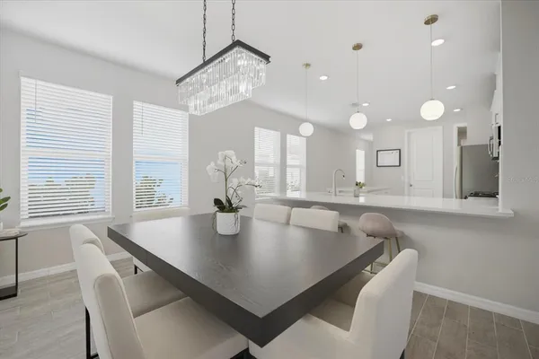 a dining room with wooden floor and large windows