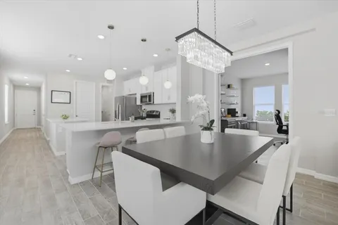 a view of kitchen and dining area with a table chairs