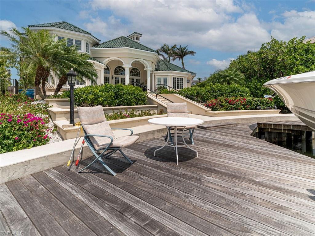 330 Devils Bight Naples, FL 34103 - Photo 16 of 47 a view of a house with wooden deck and furniture