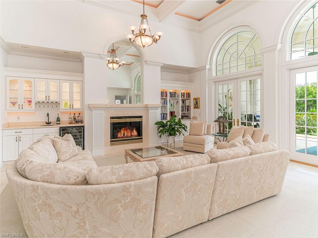 330 Devils Bight Naples, FL 34103 - Photo 26 of 47 a living room with furniture a fireplace and a chandelier