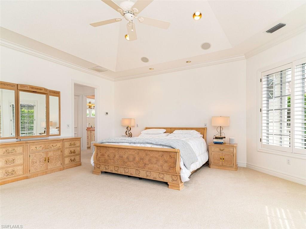 330 Devils Bight Naples, FL 34103 - Photo 28 of 47 a spacious bedroom with a bed and large windows