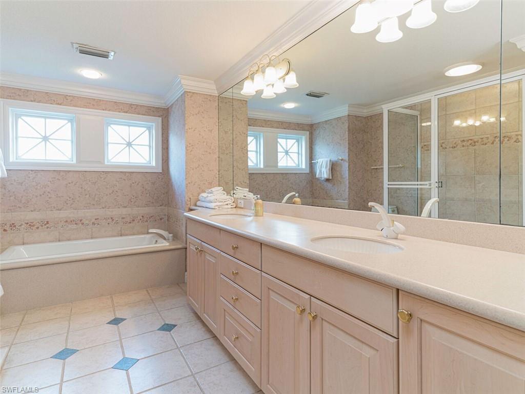 330 Devils Bight Naples, FL 34103 - Photo 30 of 47 a bathroom with a granite countertop sink a mirror and a bathtub