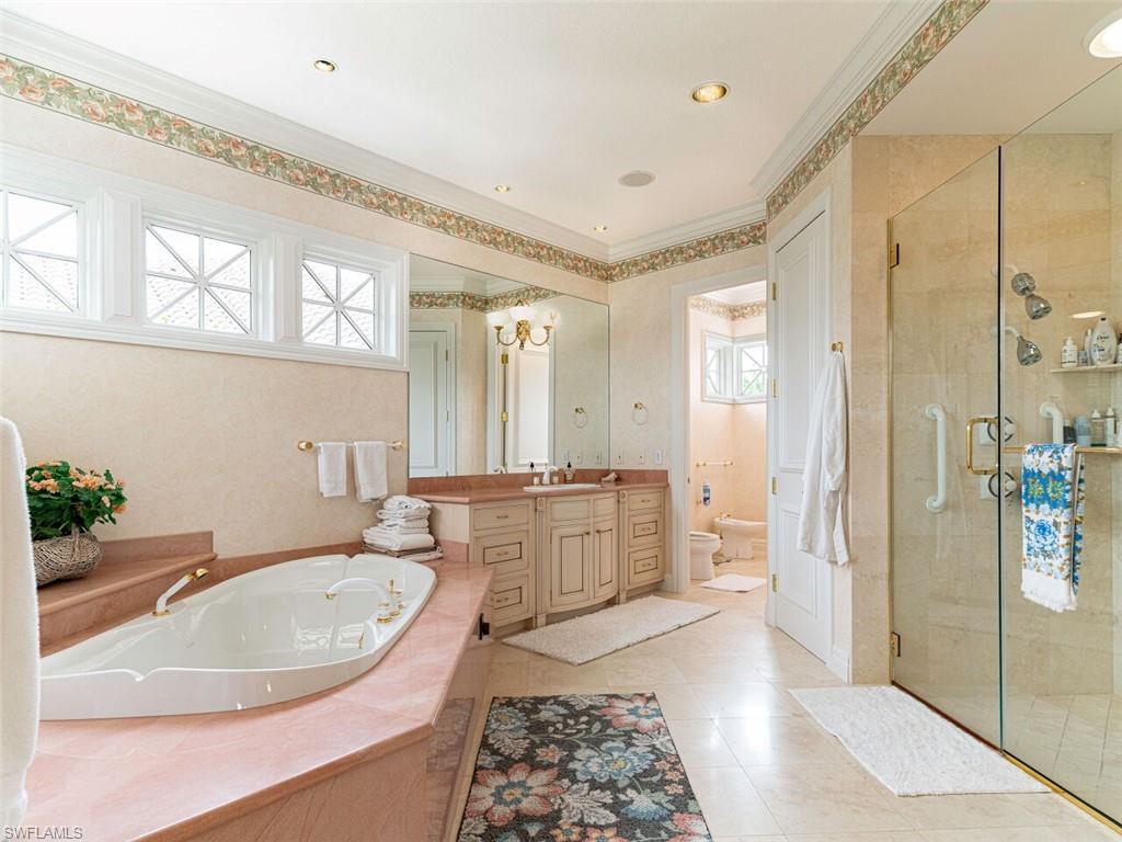 330 Devils Bight Naples, FL 34103 - Photo 31 of 47 a bathroom with a tub sink and mirror