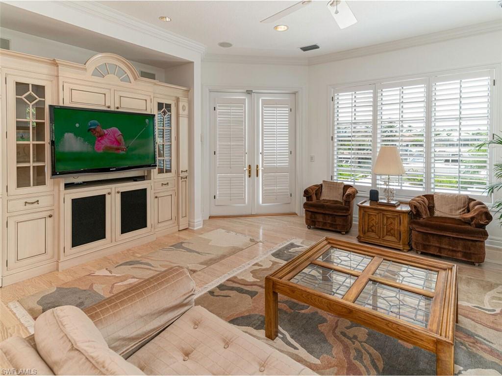 330 Devils Bight Naples, FL 34103 - Photo 37 of 47 a living room with furniture a flat screen tv and a fireplace