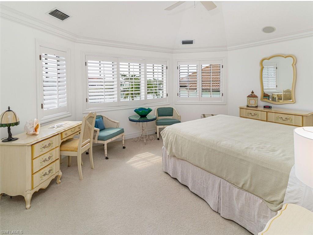 330 Devils Bight Naples, FL 34103 - Photo 41 of 47 a spacious bedroom with a bed a table and large windows
