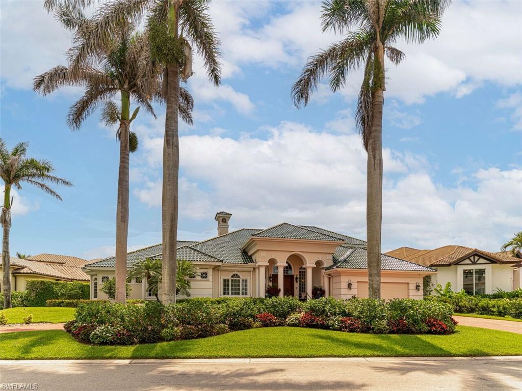 330 Devils Bight Naples, FL 34103 - Photo 5 of 47 a front view of a house with a yard and palm trees