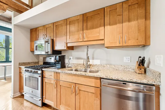 a kitchen with stainless steel appliances granite countertop a sink stove and cabinets