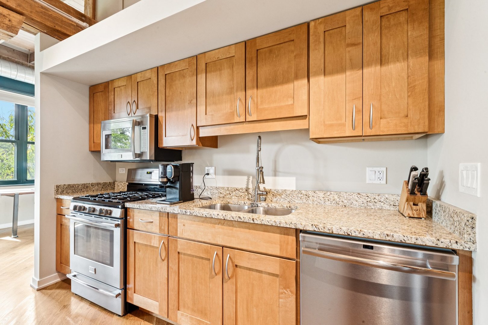 3201 North Ravenswood Avenue, Unit 301 Chicago, IL 60657 - Photo 13 of 38 a kitchen with granite countertop a sink stove top oven and cabinets