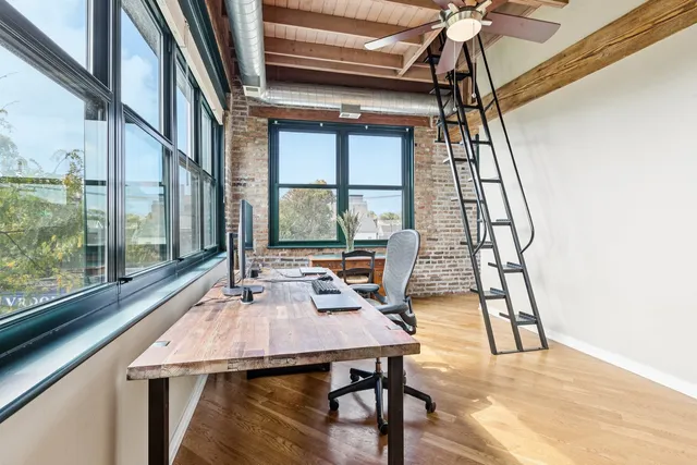 a view of a workspace with furniture and a window