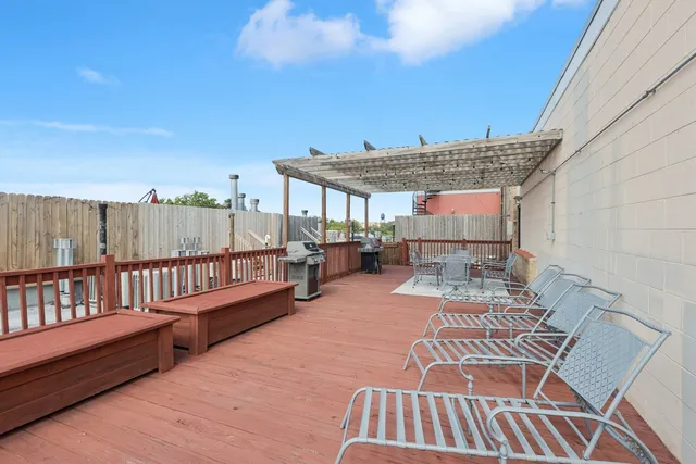 a view of a roof deck with table and chairs