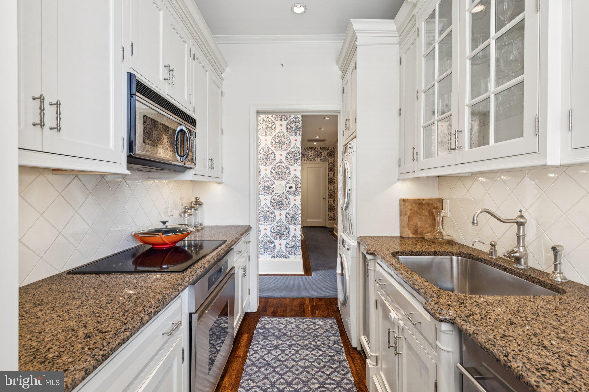 237-47 South 18th Street, Unit 4D Philadelphia, PA 19103 - Photo 7 of 19 a kitchen with stainless steel appliances granite countertop a sink stove and cabinets