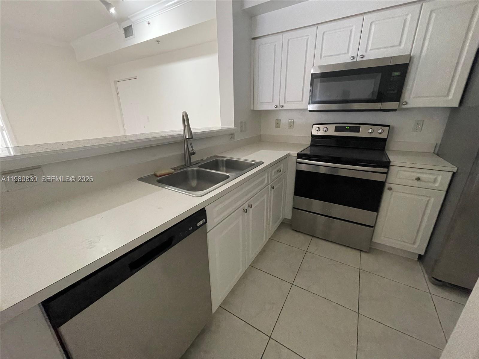 6821 Southwest 44th Street, Unit 301 Miami, FL 33155 - Photo 6 of 12 a kitchen with a sink and white cabinets