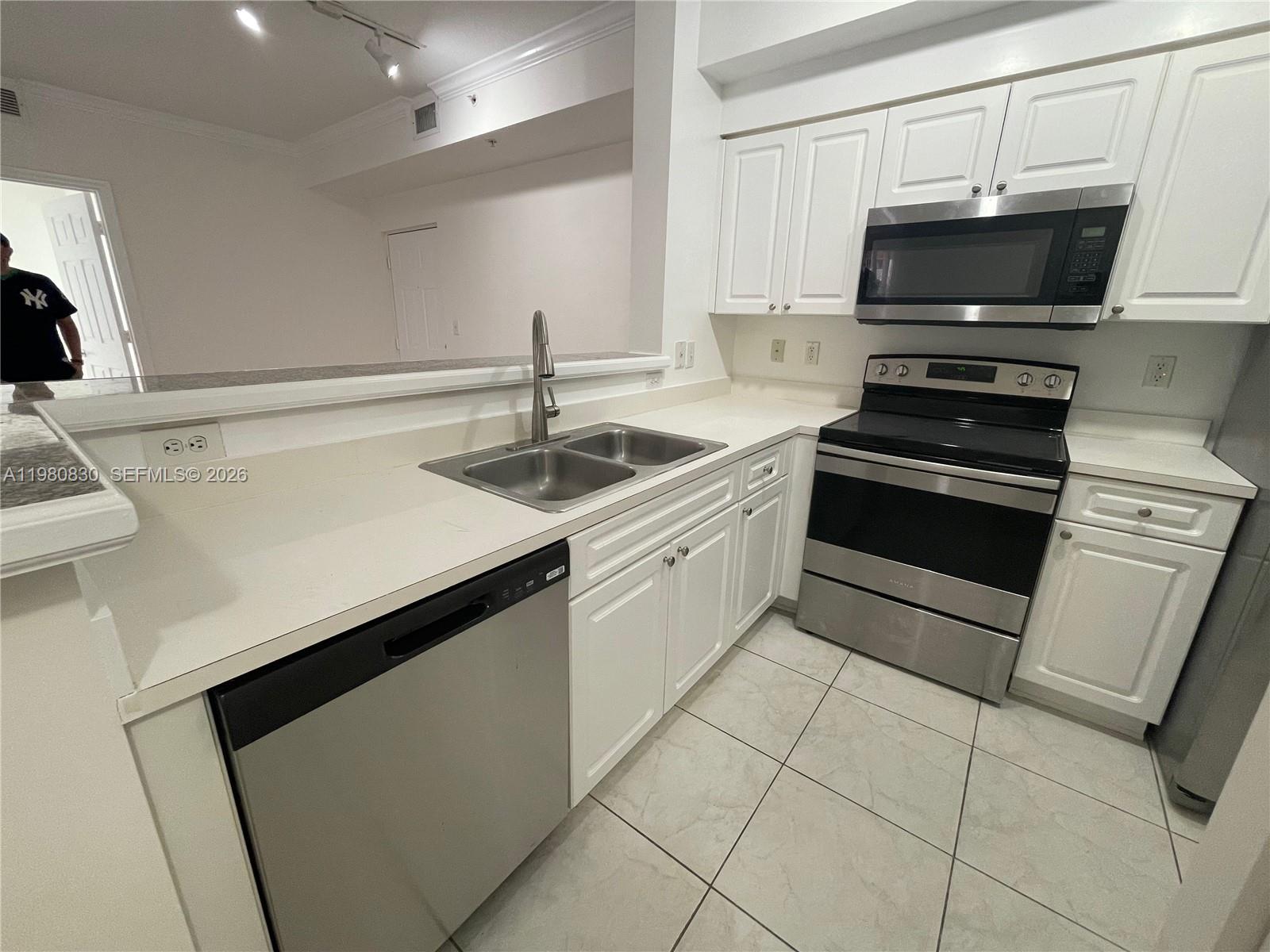 6821 Southwest 44th Street, Unit 301 Miami, FL 33155 - Photo 7 of 12 a kitchen with a sink and a stove top oven