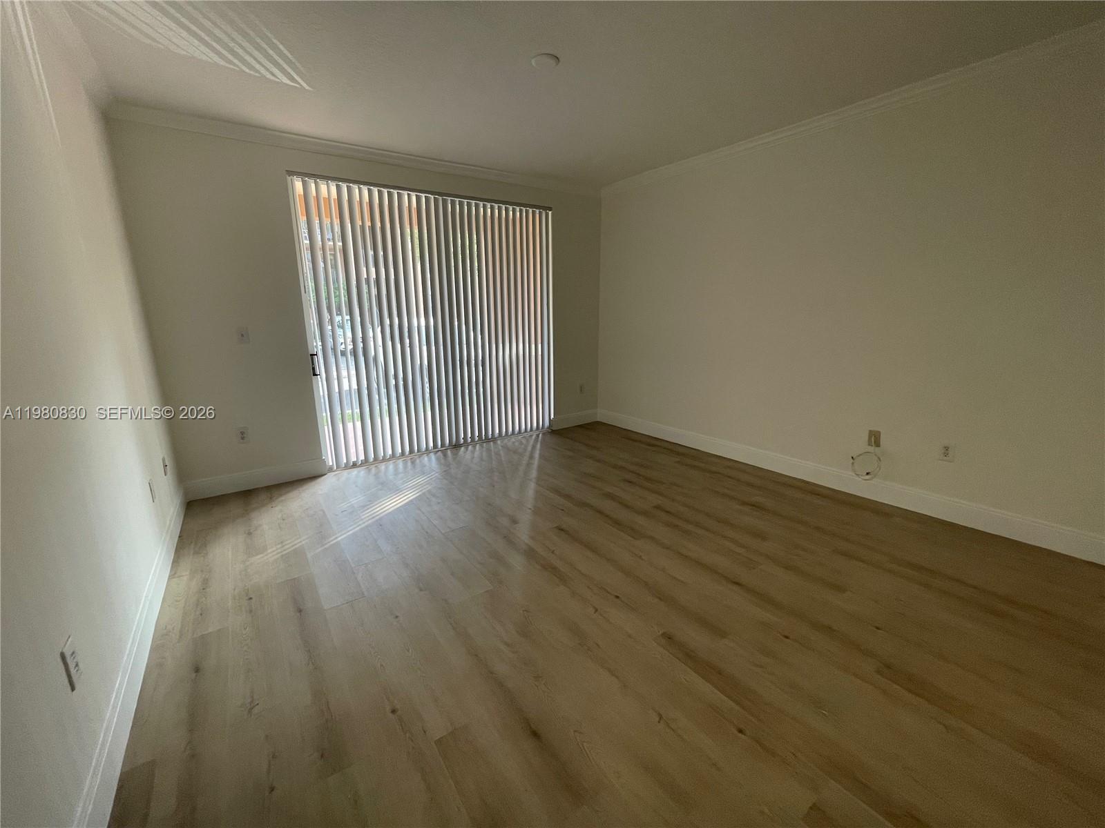 6821 Southwest 44th Street, Unit 301 Miami, FL 33155 - Photo 10 of 12 an empty room with wooden floor and windows