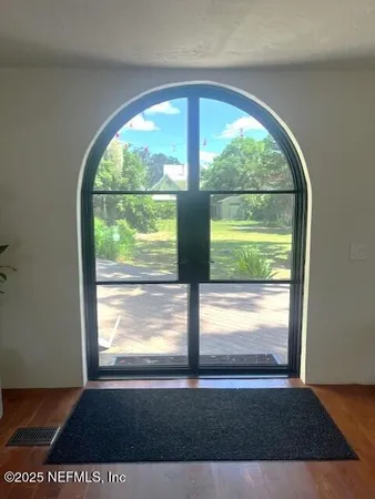 a view of empty room with wooden floor and a floor to ceiling window